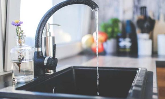 Islington plumbing and heating installation: modern kitchen tap with flowing water.