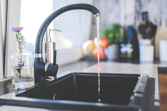 Islington plumbing and heating installation: modern kitchen tap with flowing water.