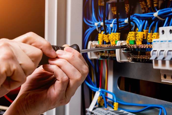 Islington Electrical & Ventilation Service – electrician working on circuit board wiring with screwdriver