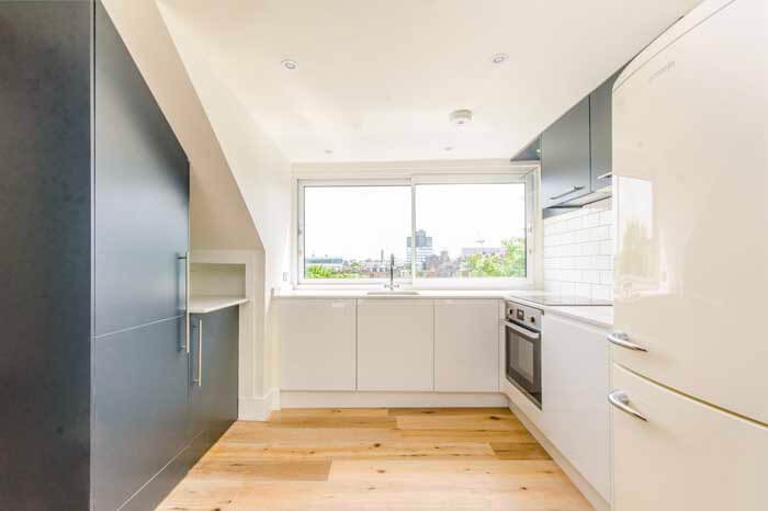 Islington kitchen renovation – modern white cabinets, wood flooring, and integrated appliances at Loraine Rd N7 project