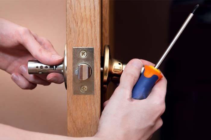 Islington Property Maintenance – handyman repairing door lock with screwdriver