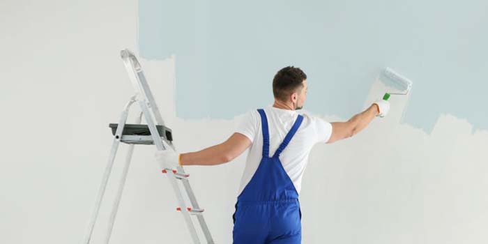 Professional painter decorating interior wall in Islington home avoiding common painting mistakes